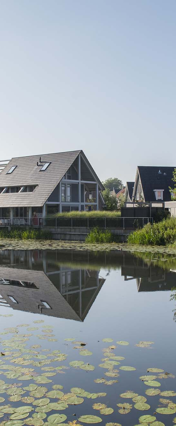 Een sloot met aan het water woningen van De Tuin van Elden