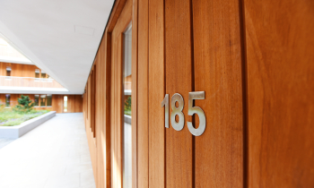 Detail foto van een nummerplaatje bij een appartement, de foto is schuin genomen