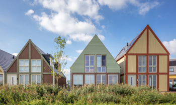 Drie verschillende gevels van woningen met groen op de voorgrond