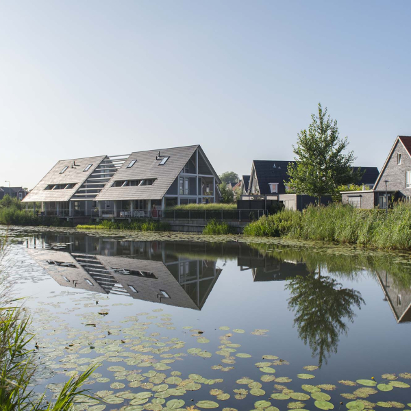 Een sloot met aan het water woningen van De Tuin van Elden